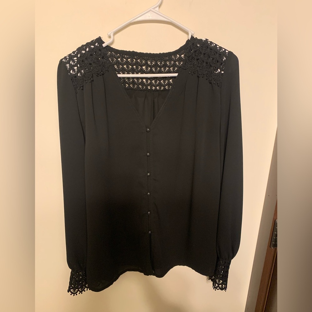Black blouse with crochet detailing. Intricate buttons up the front.